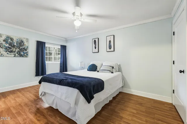 a spacious bedroom with a bed and wooden floor