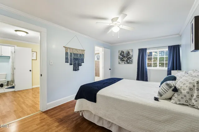 a bedroom with a large bed chandelier and a window