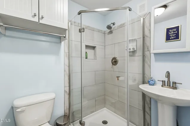 a bathroom with a shower a toilet and sink