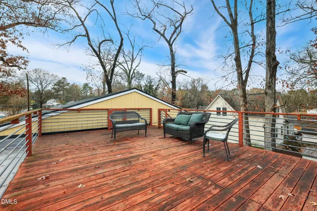 a backyard of a house with wooden floor and outdoor seating