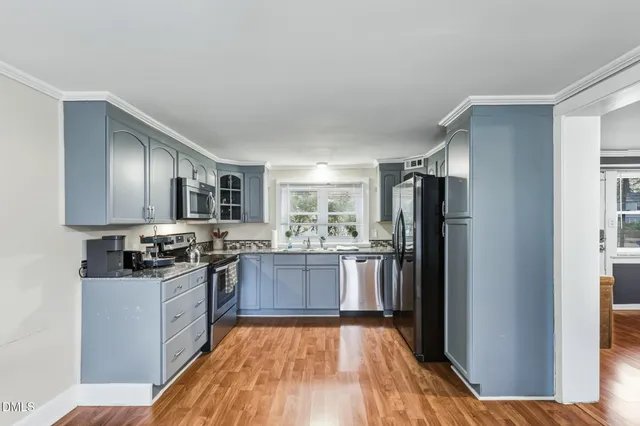 a kitchen with stainless steel appliances granite countertop a refrigerator stove and sink