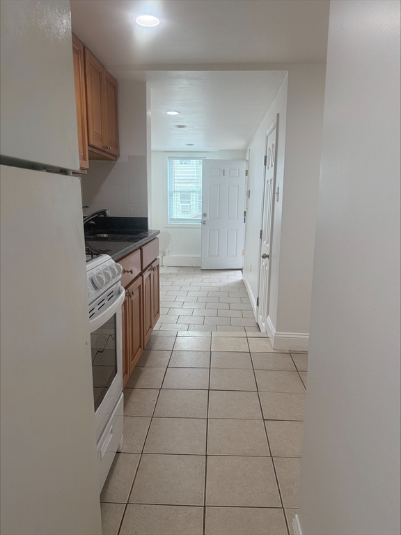 104 Beacon Street, Unit 1A Chelsea, MA 02150 - Photo 8 of 9 a kitchen with a stove top oven cabinets and stainless steel appliances