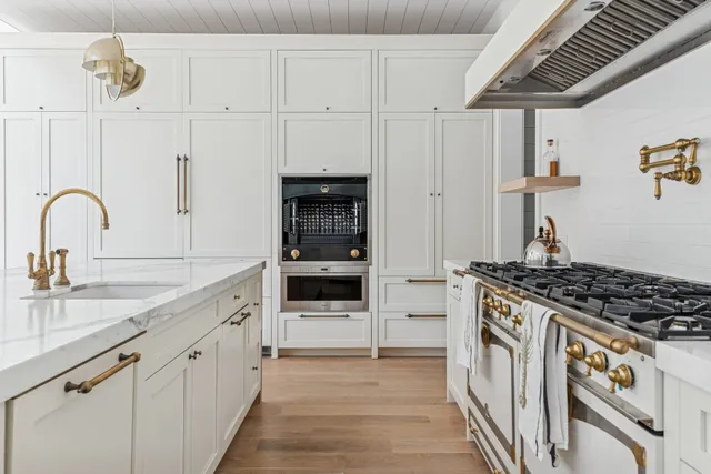 a living room with furniture large windows and wooden floor