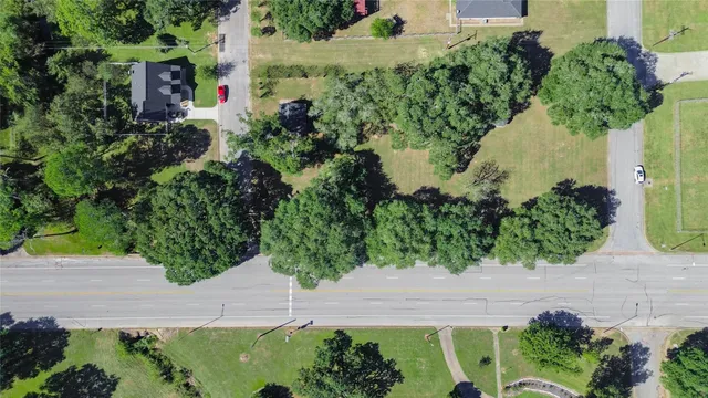 an aerial view of residential house with outdoor space and trees all around