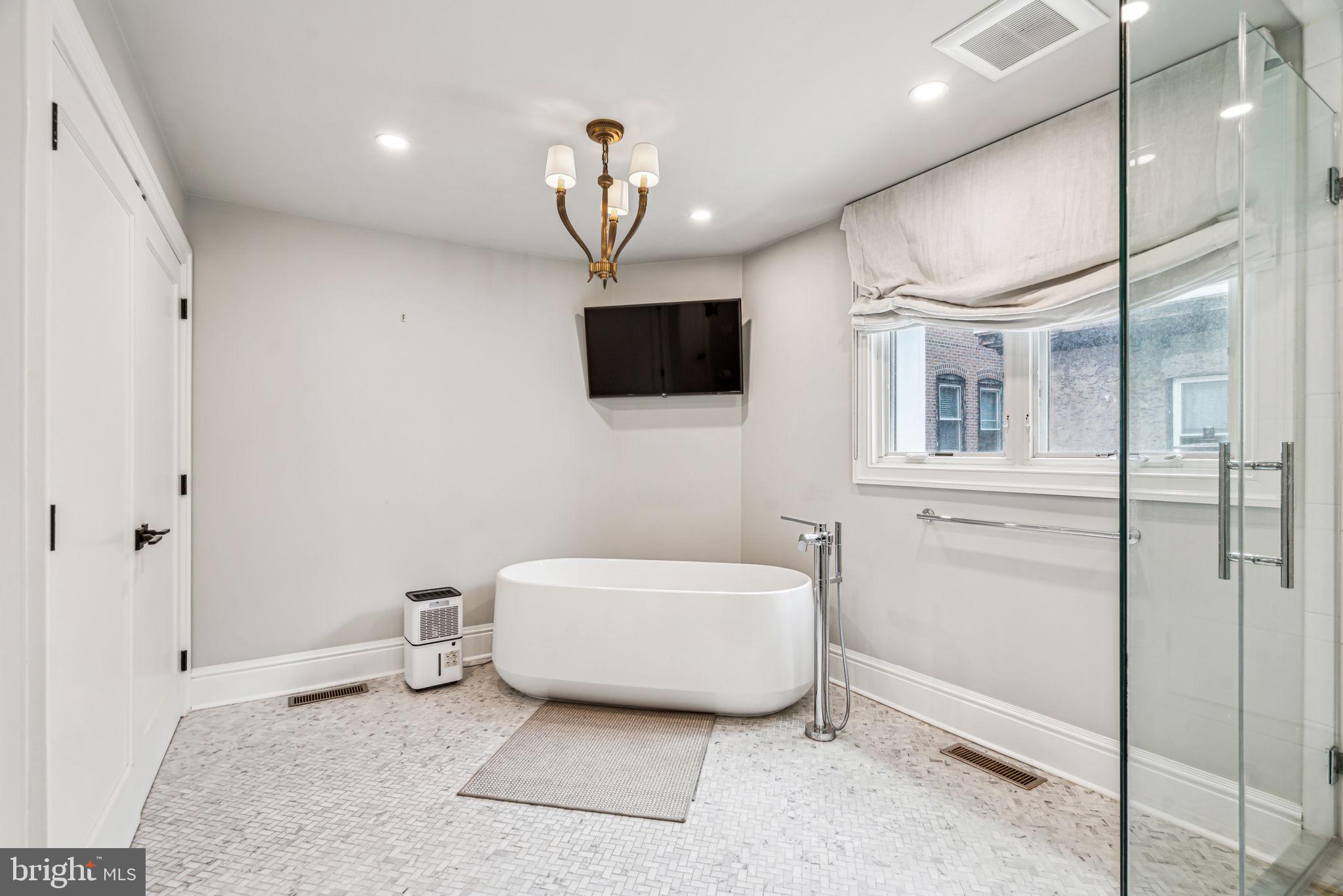 1710 Rittenhouse Square Philadelphia, PA 19103 - Photo 18 of 28 a spacious bedroom with a bed and a flat screen tv
