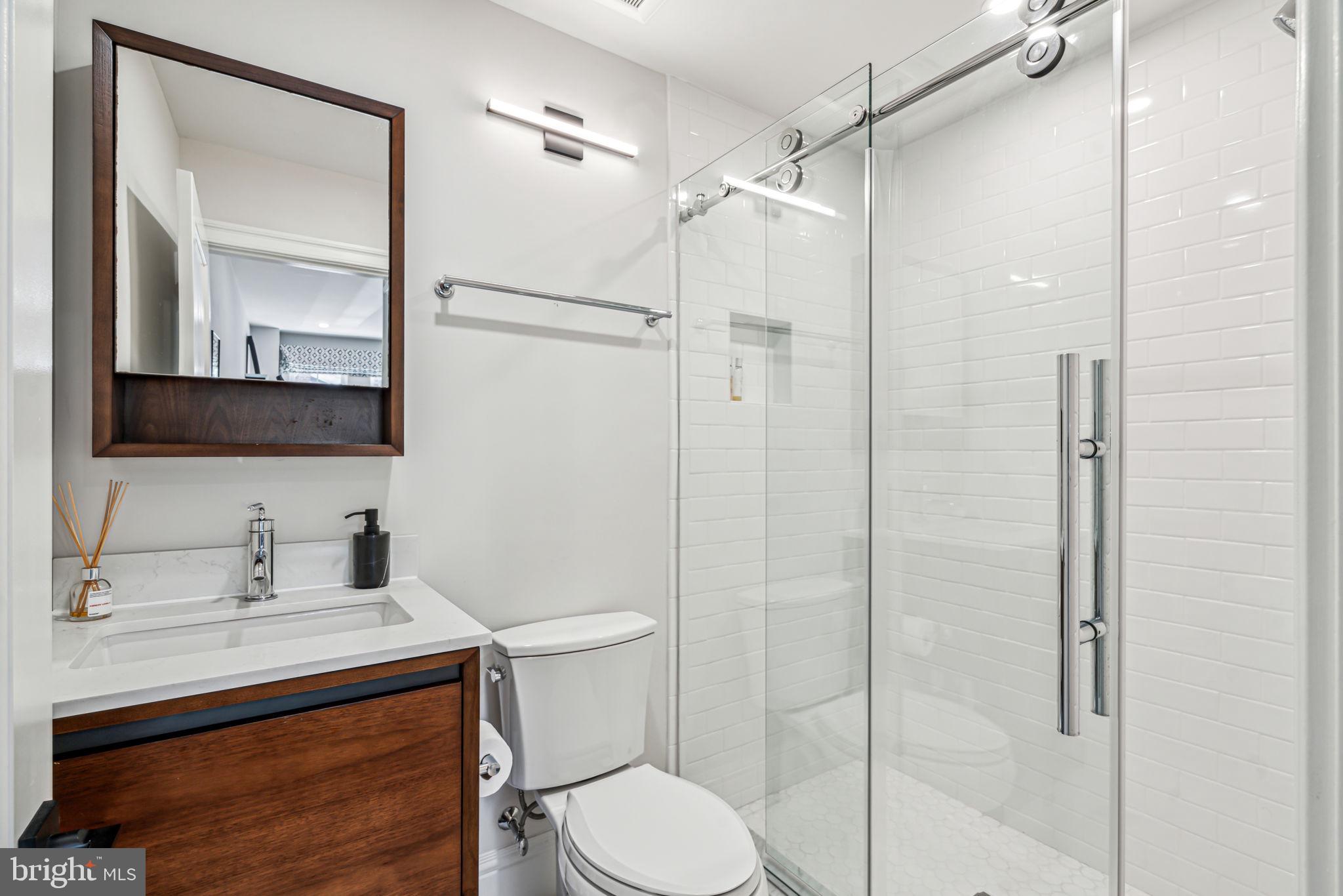 1710 Rittenhouse Square Philadelphia, PA 19103 - Photo 25 of 28 a bathroom with a shower sink vanity mirror and toilet