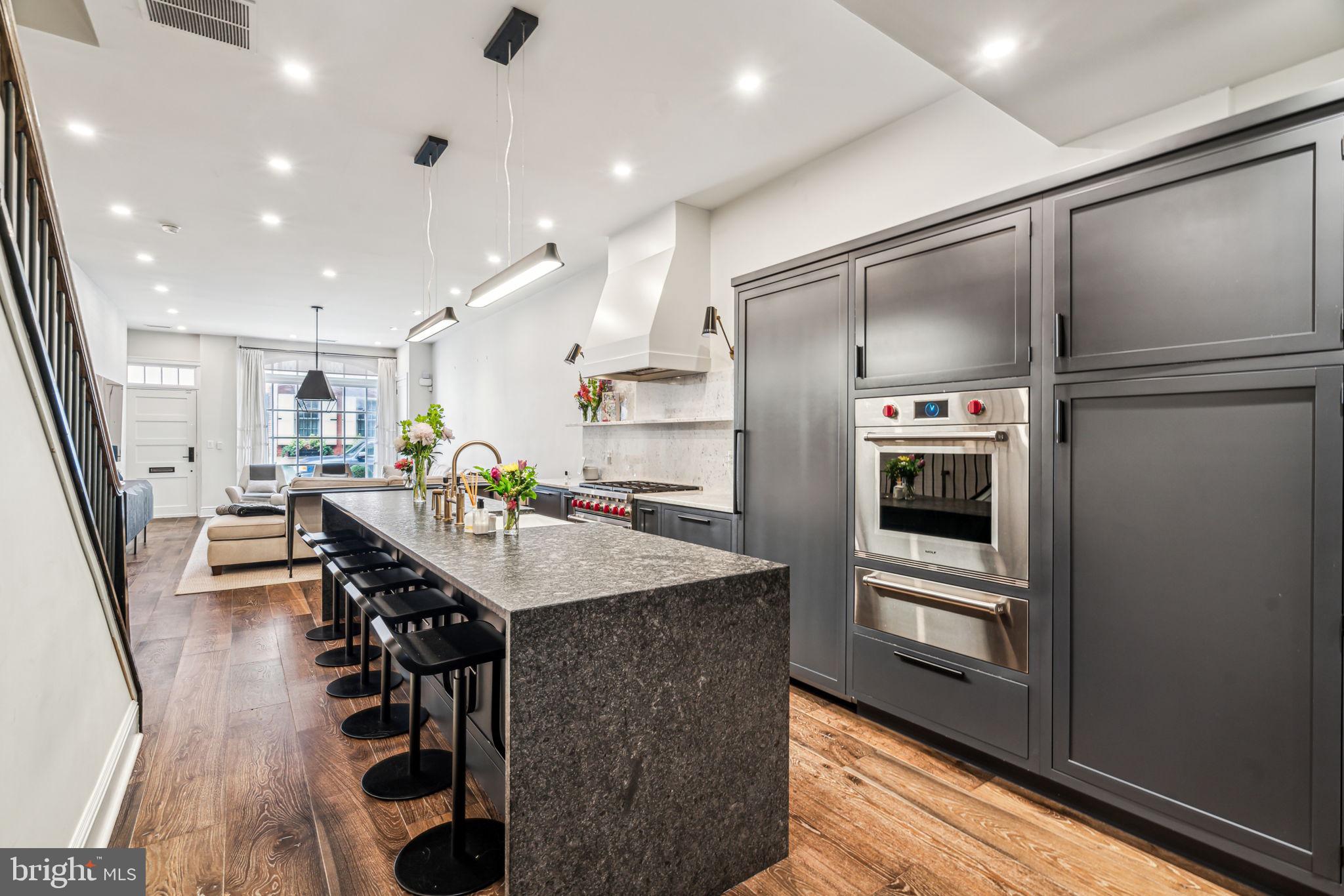 1710 Rittenhouse Square Philadelphia, PA 19103 - Photo 8 of 28 a kitchen with stainless steel appliances kitchen island granite countertop a refrigerator a stove and a sink with wooden floor