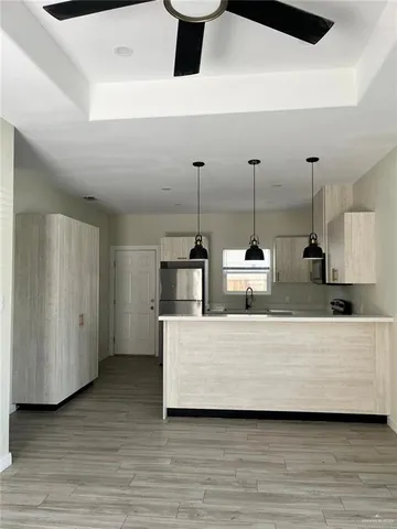 a kitchen with a sink cabinets and wooden floor