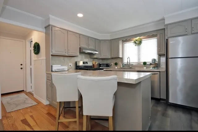 a kitchen with stainless steel appliances granite countertop a white cabinets and a refrigerator