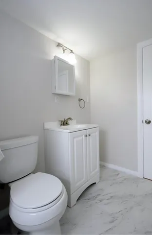 a bathroom with a toilet a sink and mirror