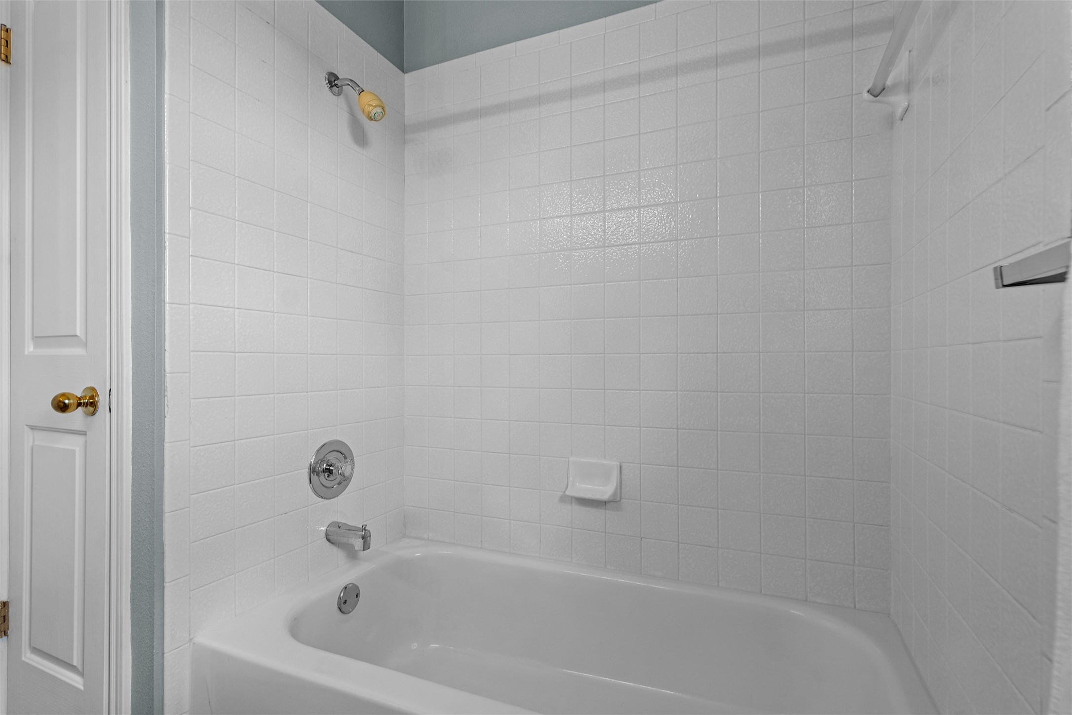 7000 Colberg Court Austin, TX 78749 - Photo 27 of 40 A pristine white tiled shower-over-tub combination offers a tranquil bathing retreat.