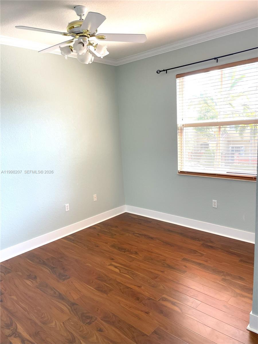 3377 Merrick Lane, Unit 707 Margate, FL 33063 - Photo 26 of 33 an empty room with wooden floor fan and windows
