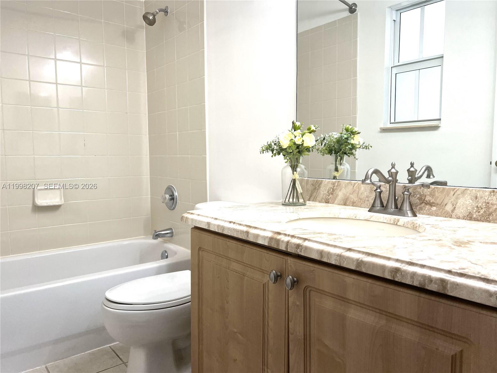3377 Merrick Lane, Unit 707 Margate, FL 33063 - Photo 28 of 33 a bathroom with a granite countertop sink a toilet and bathtub