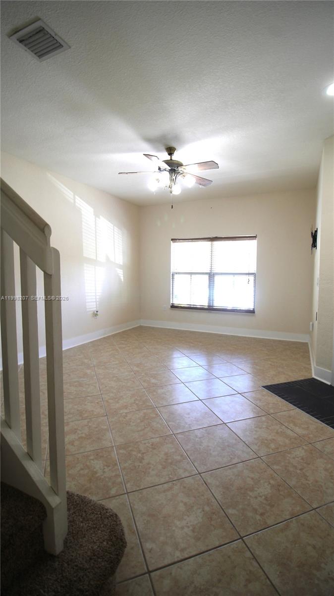 3377 Merrick Lane, Unit 707 Margate, FL 33063 - Photo 6 of 33 an empty room with windows and ceiling fan