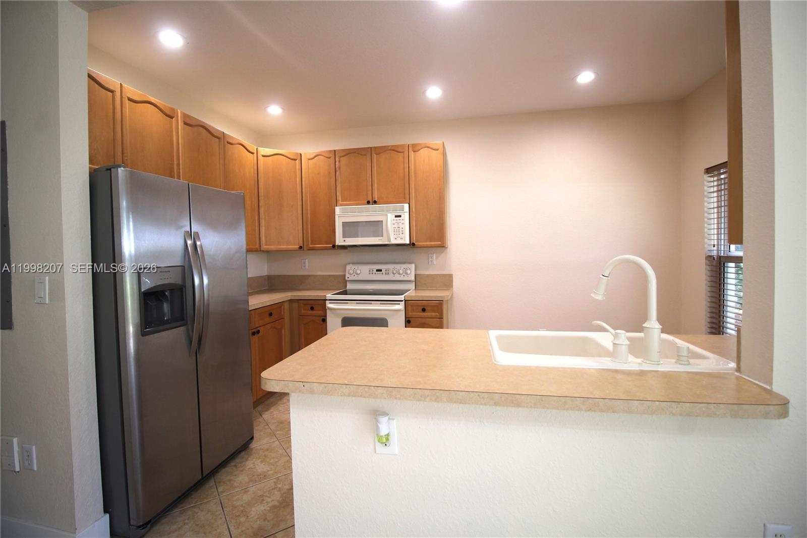 3377 Merrick Lane, Unit 707 Margate, FL 33063 - Photo 10 of 33 a kitchen with a refrigerator and a sink