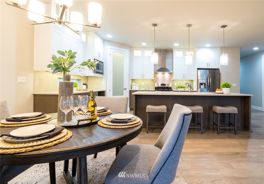 7155 Teal Loop Gig Harbor, WA 98335 - Photo 19 of 40 a dining room filled chandelier and wooden floor