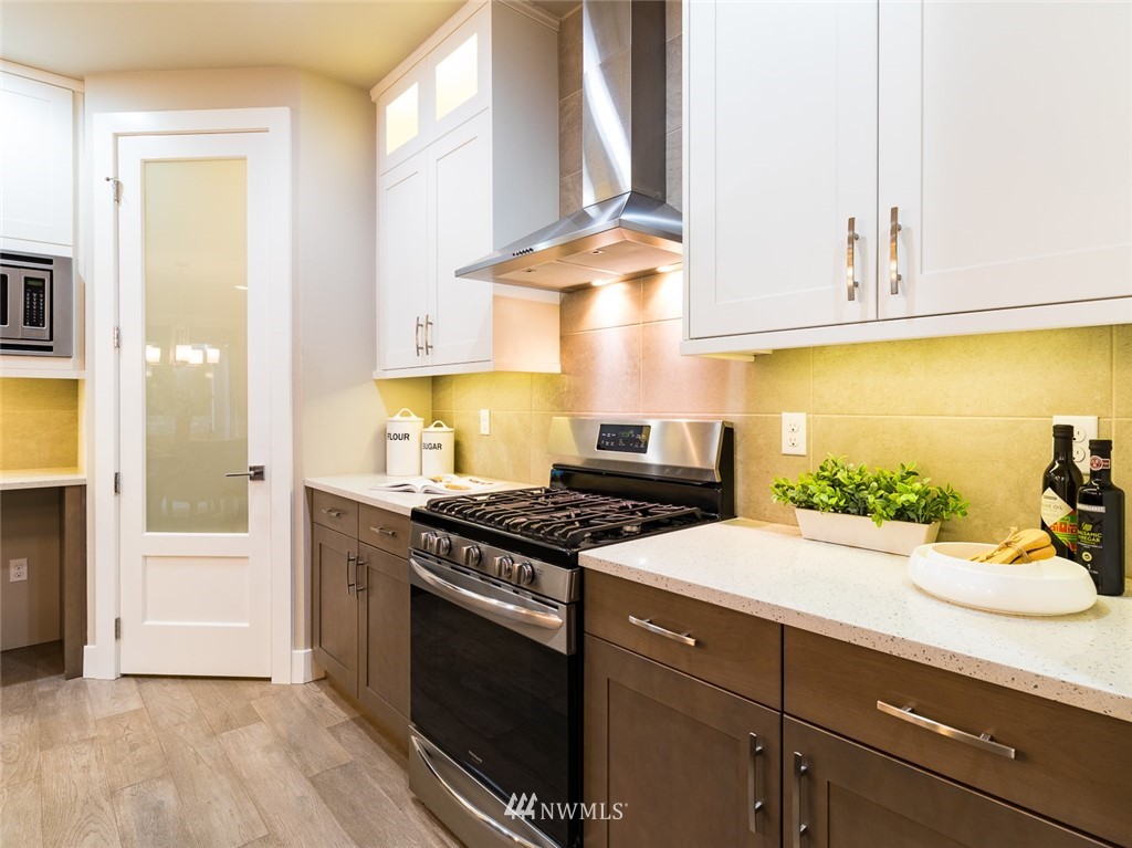 7155 Teal Loop Gig Harbor, WA 98335 - Photo 21 of 40 a kitchen with stainless steel appliances a stove a sink and a refrigerator with wooden floor
