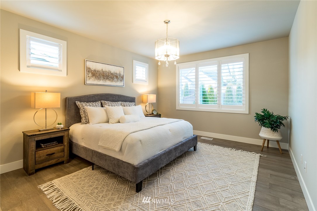 7155 Teal Loop Gig Harbor, WA 98335 - Photo 31 of 40 a bedroom with a bed and a chandelier