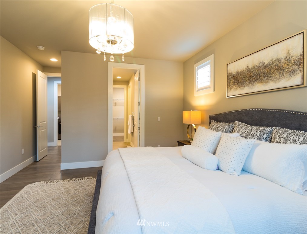 7155 Teal Loop Gig Harbor, WA 98335 - Photo 32 of 40 a bedroom with a bed and a chandelier