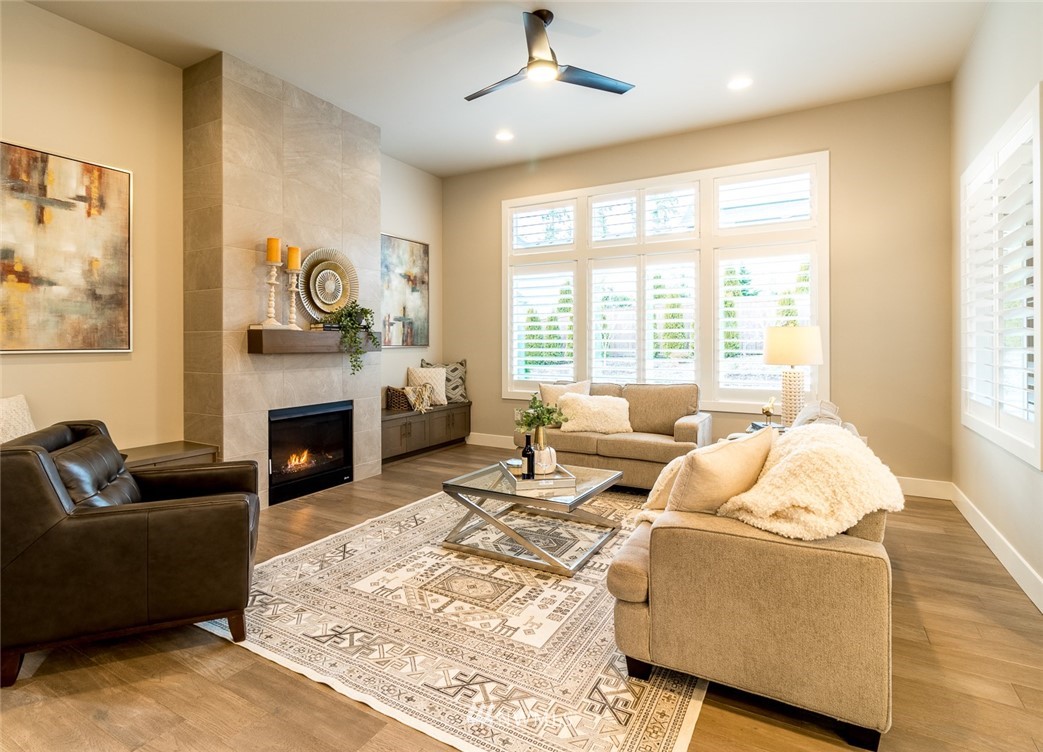 7155 Teal Loop Gig Harbor, WA 98335 - Photo 4 of 40 a living room with furniture a fireplace and a large window
