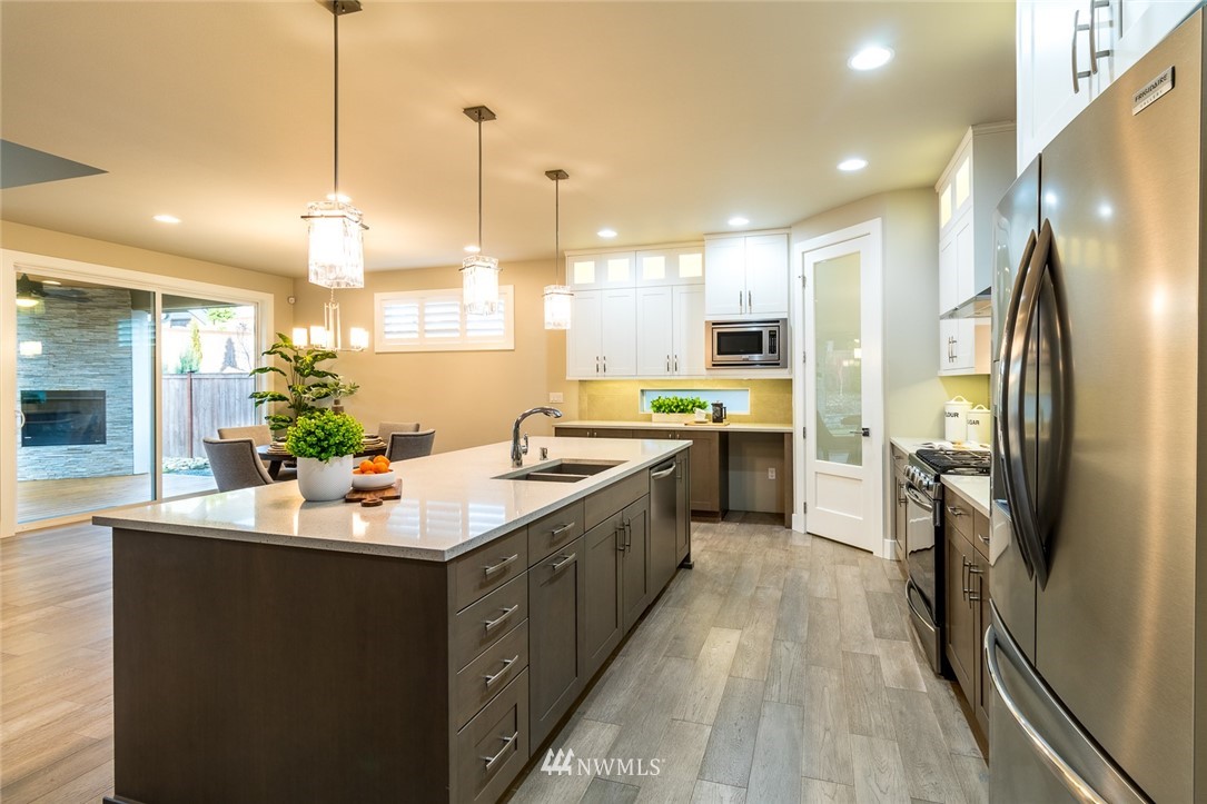 7155 Teal Loop Gig Harbor, WA 98335 - Photo 6 of 40 a kitchen with kitchen island granite countertop a sink appliances and cabinets