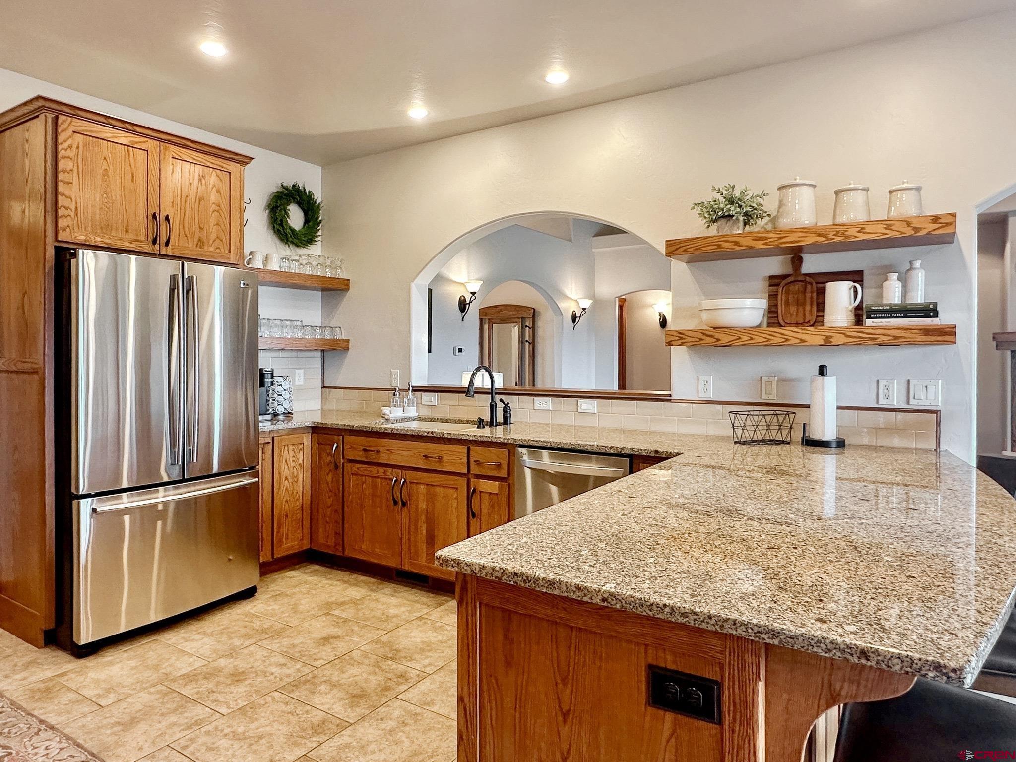 1787 Roubideau Street Delta, CO 81416 - Photo 15 of 35 a kitchen with stainless steel appliances granite countertop a refrigerator a sink and a stove