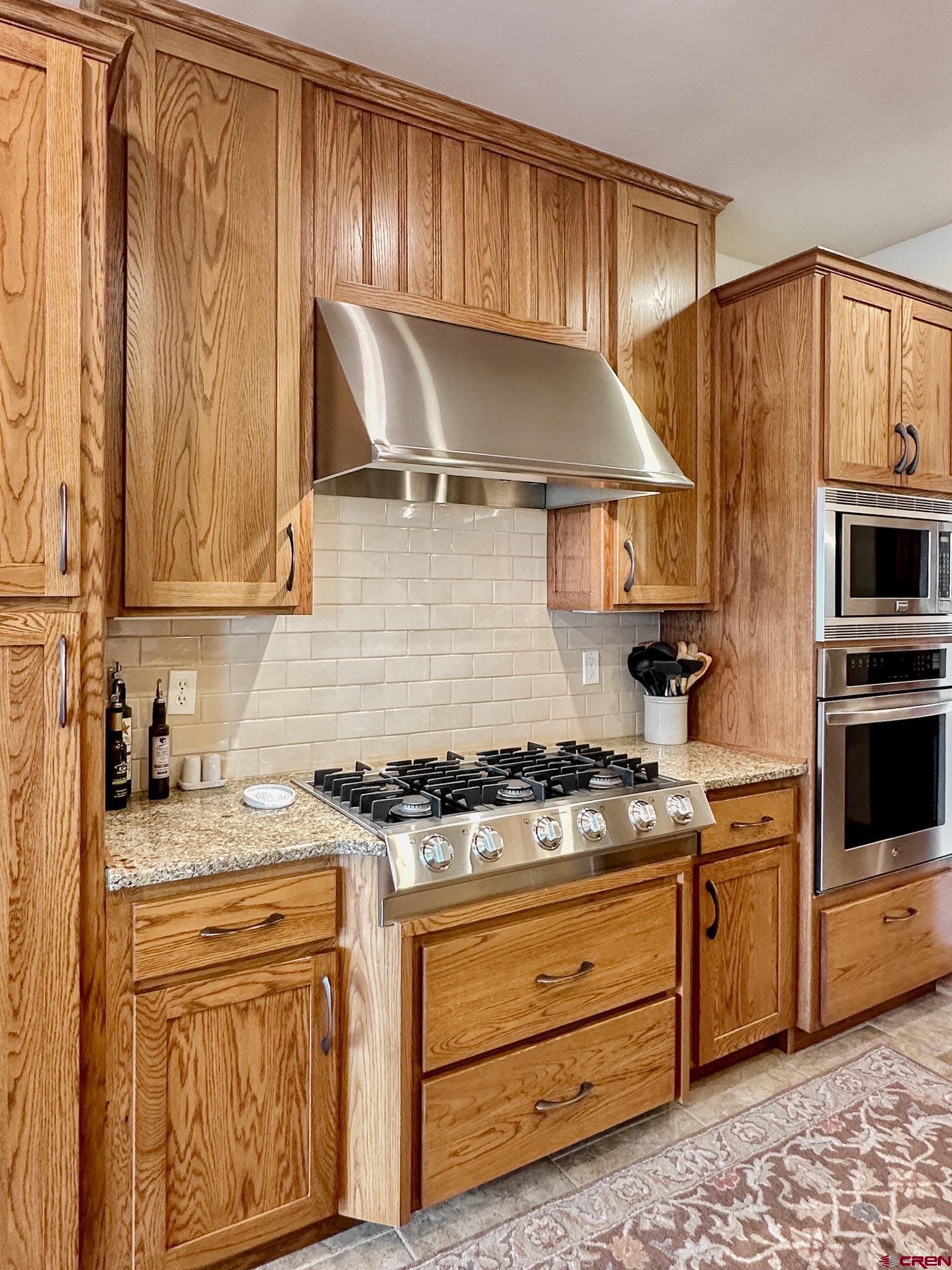 1787 Roubideau Street Delta, CO 81416 - Photo 16 of 35 a kitchen with stainless steel appliances granite countertop a stove and a sink