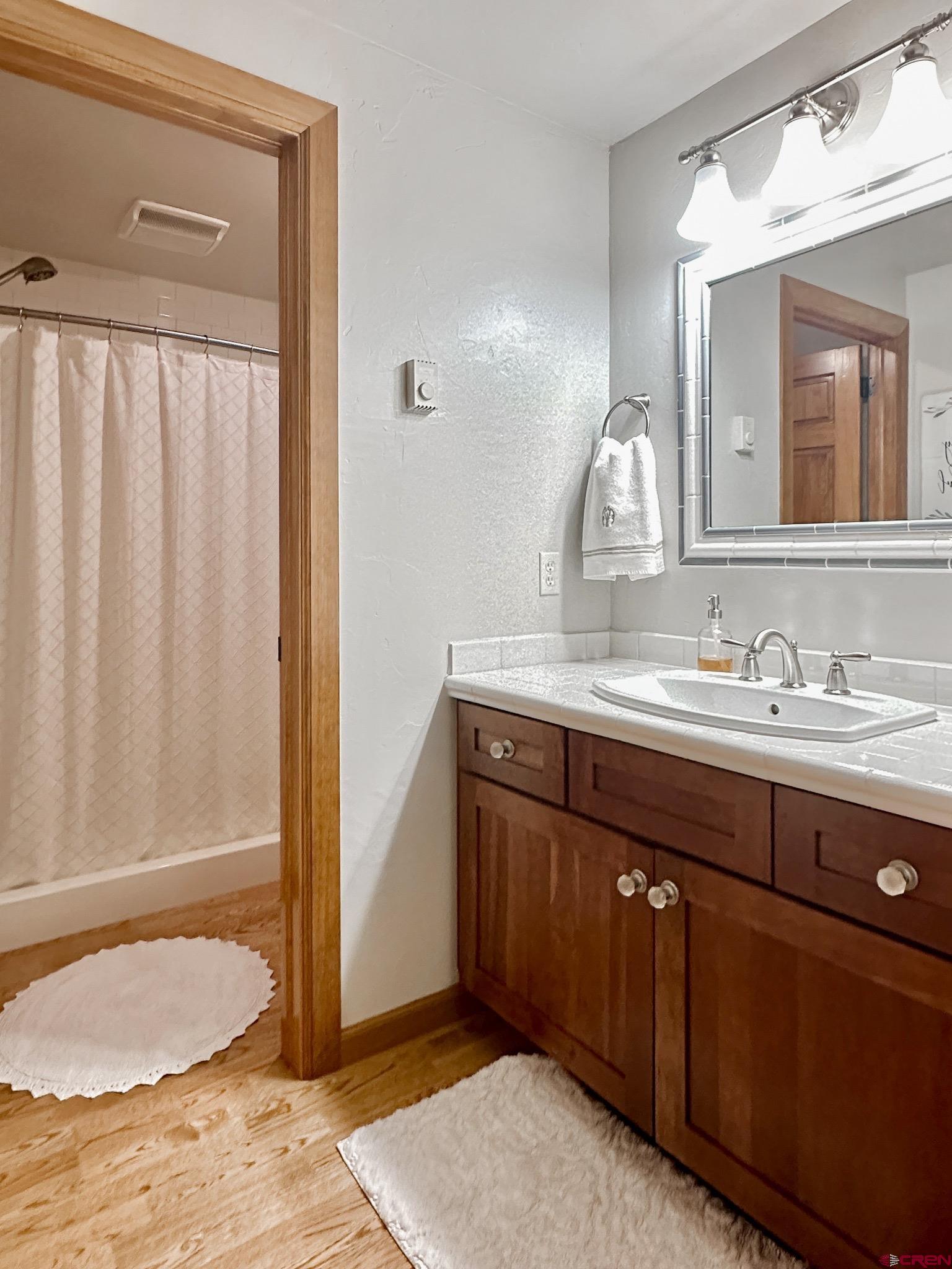 1787 Roubideau Street Delta, CO 81416 - Photo 28 of 35 a bathroom with a granite countertop sink and a mirror