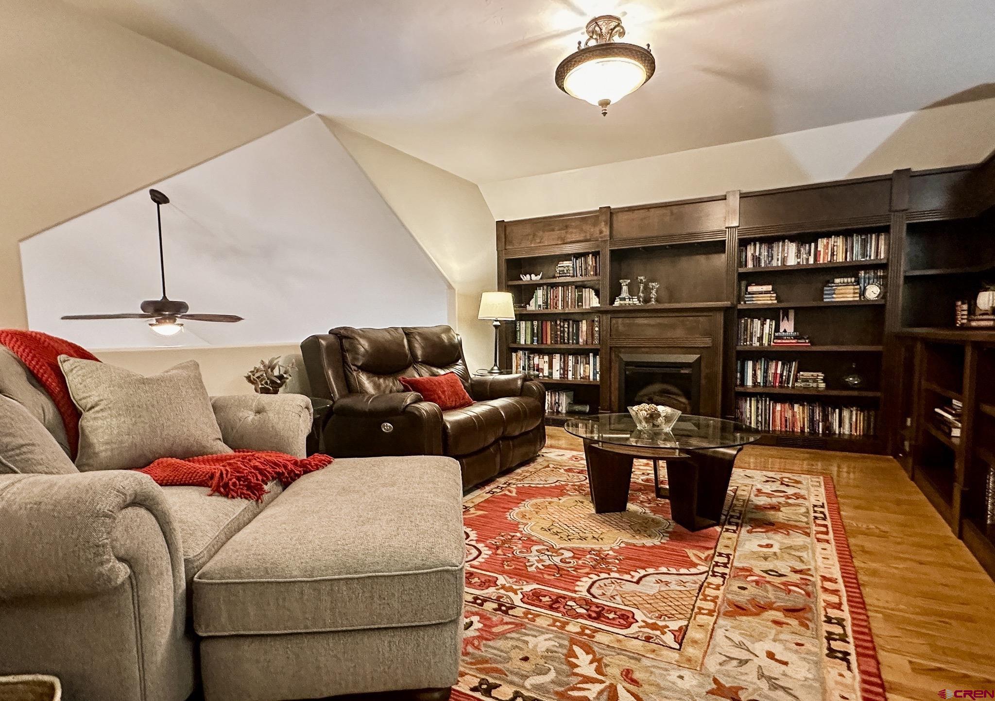 1787 Roubideau Street Delta, CO 81416 - Photo 32 of 35 a living room with furniture a rug and a book shelf