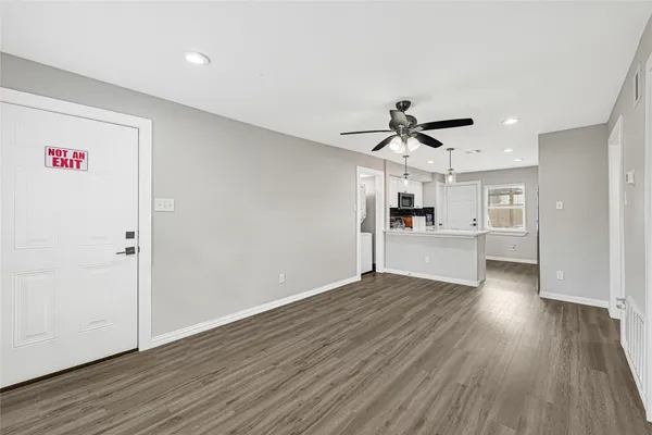 a view of a kitchen with wooden floor and a ceiling fan