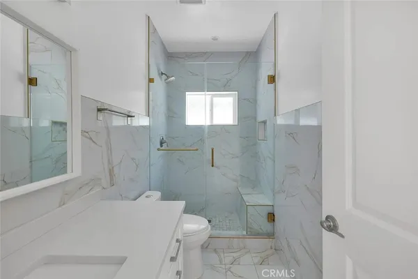 a bathroom with a sink a toilet and shower