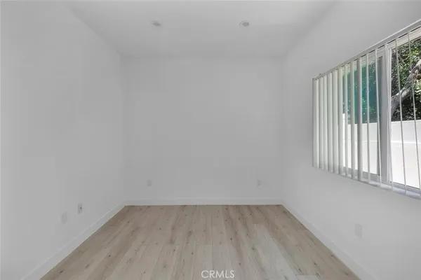 a view of a small space with wooden floor and a window