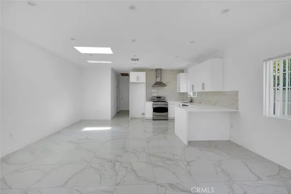 a view of a kitchen with white cabinets and white appliances