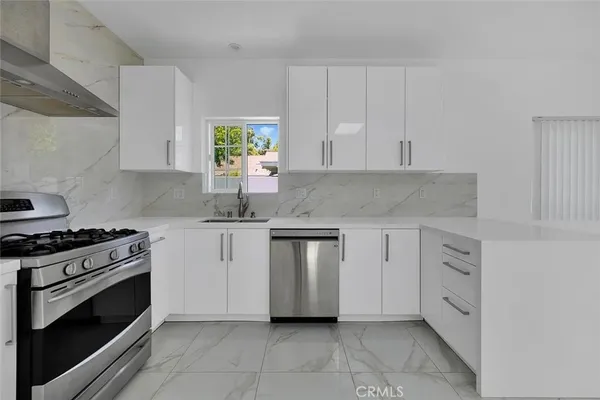a kitchen with white cabinets and appliances
