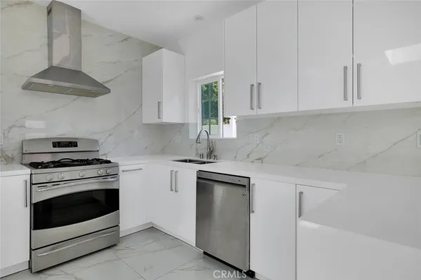 a kitchen with white cabinets and white appliances