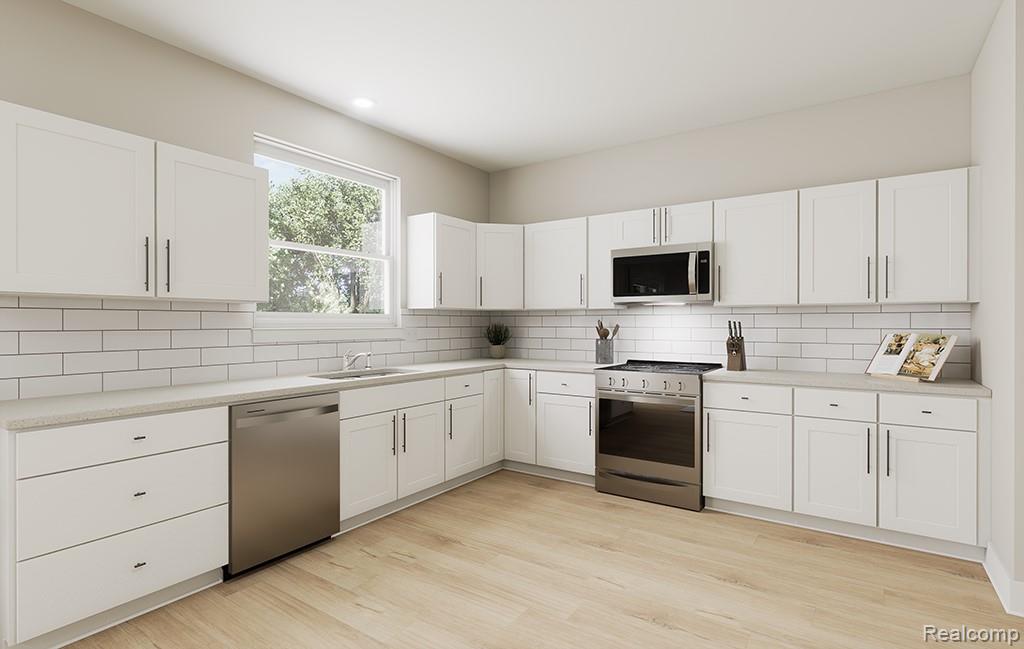 61659 Empire Road South Lyon, MI 48178 - Photo 11 of 21 Kitchen featuring stainless steel appliances, white cabinets, backsplash, light wood-style flooring, and recessed lighting