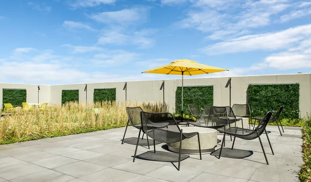 a patio with a table and chairs under an umbrella