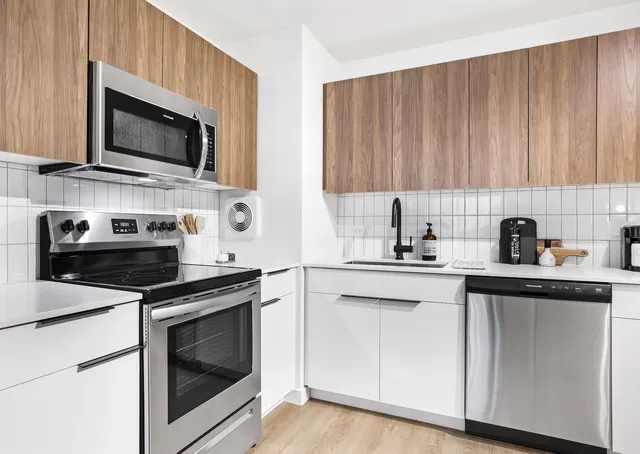 a kitchen with stainless steel appliances granite countertop a sink a stove a microwave and cabinets