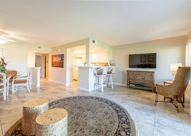 a living room with furniture a rug and a flat screen tv