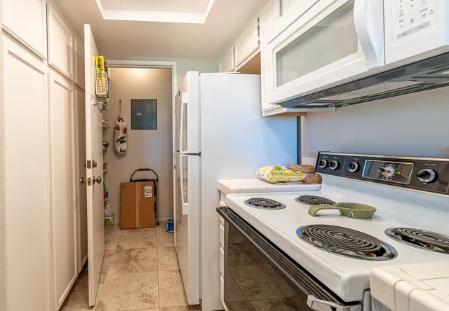 a kitchen with a refrigerator a stove and a cabinets