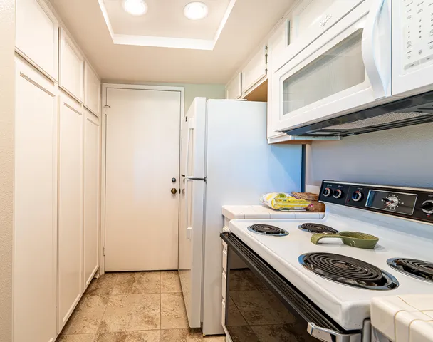 a kitchen with a refrigerator a stove and a window