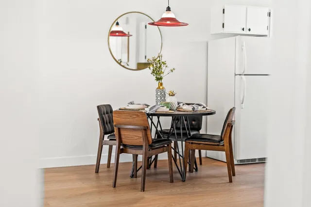 a dining room with furniture potted plants and wooden floor