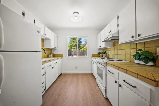 a kitchen with cabinets a sink a window and stainless steel appliances
