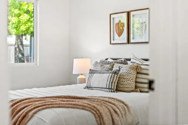 a bedroom with bed and painting on the wall