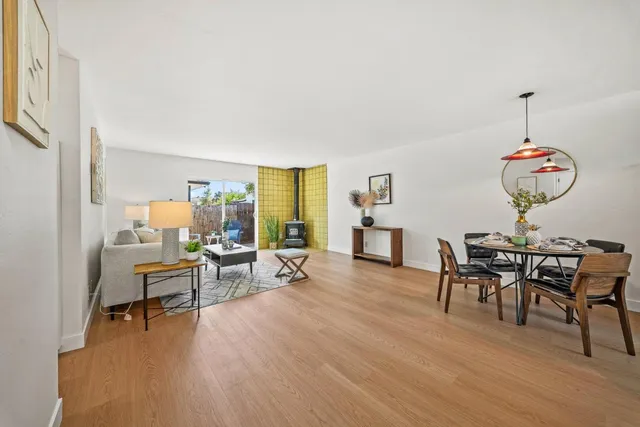 a living room with furniture wooden floor and dining table