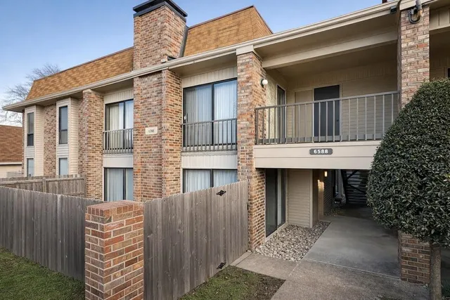 a front view of a house with a tree