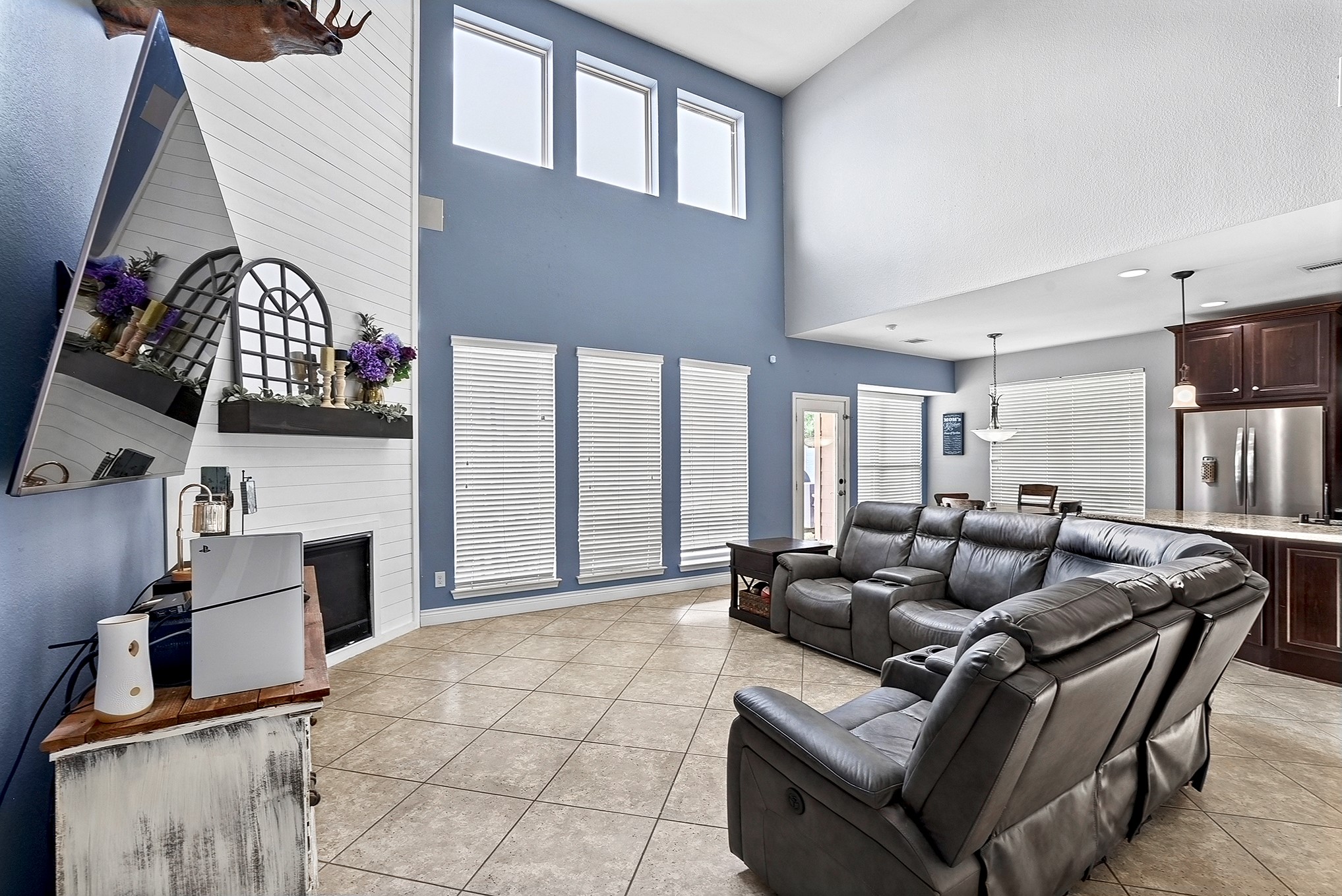 2951 Bobby Jones Road Katy, TX 77494 - Photo 21 of 50 This open-concept living room, kitchen, and breakfast area creates a spacious and inviting atmosphere. Elevated ceilings enhance the sense of openness, while the drop-down ceiling fan adds comfort. Endless windows offer breathtaking views of the backyard oasis, seamlessly blending indoor and outdoor living.