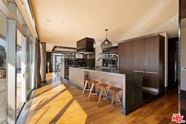 a kitchen with stainless steel appliances kitchen island granite countertop a refrigerator and a stove top oven