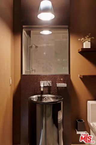 a bathroom with a toilet sink and mirror