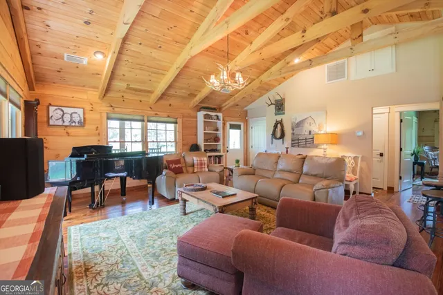 a bedroom with a bed a dresser and wooden floor